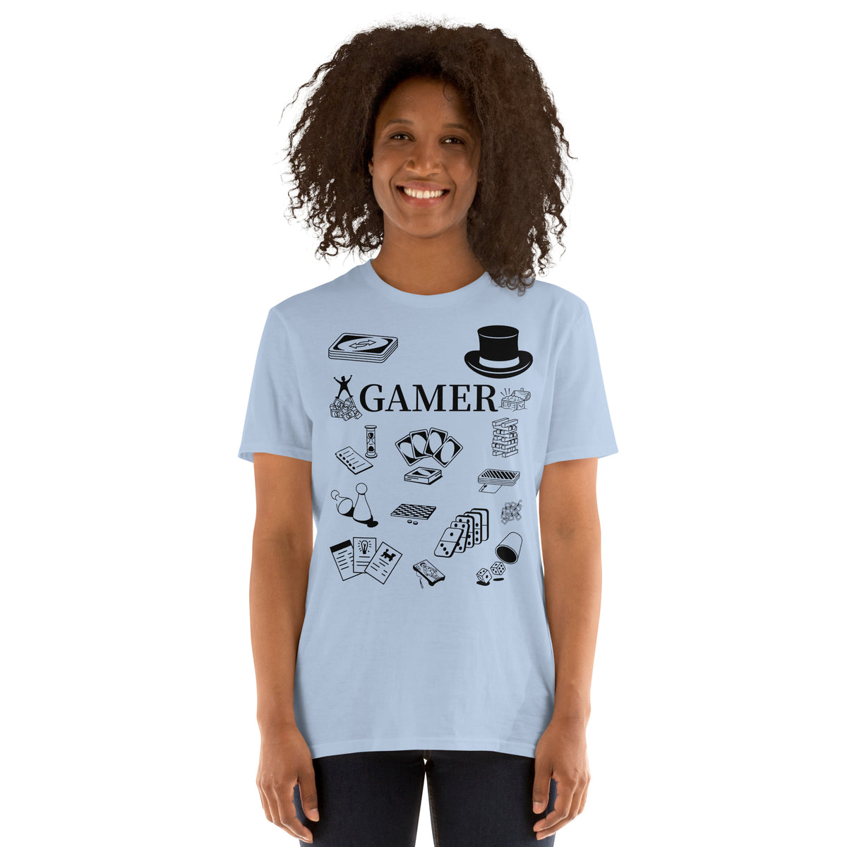 Model is standing against a white background wearing front facing graphic T-shirt in color light blue, featuring printed image of various classic board game pieces and the word 'GAMER' in black print, from What Was Said (Statement Apparel + More).