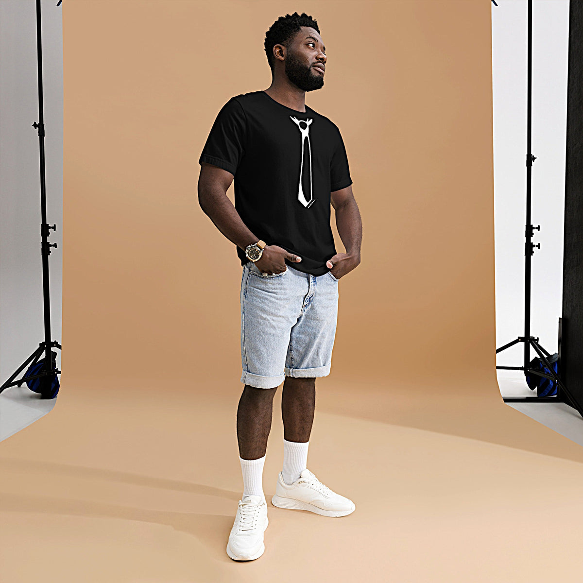Model wearing front facing graphic T-shirt in color black, featuring printed image of men's neck tie, and the written word 'FORMAL', with a strike through it, in white print. From What Was Said (Statement Apparel + More). 