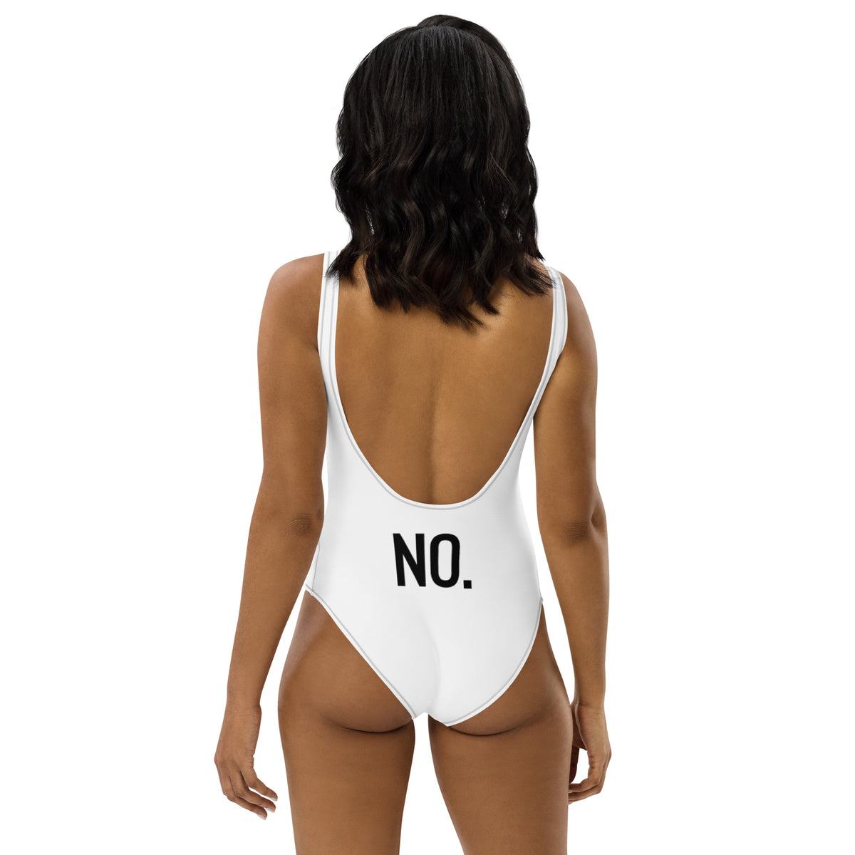 Model is wearing back facing adult graphic one-piece swimsuit in color white with black stitch trim, featuring the statement 'NO.' in bold black print. From What Was Said (Statement Apparel + More).