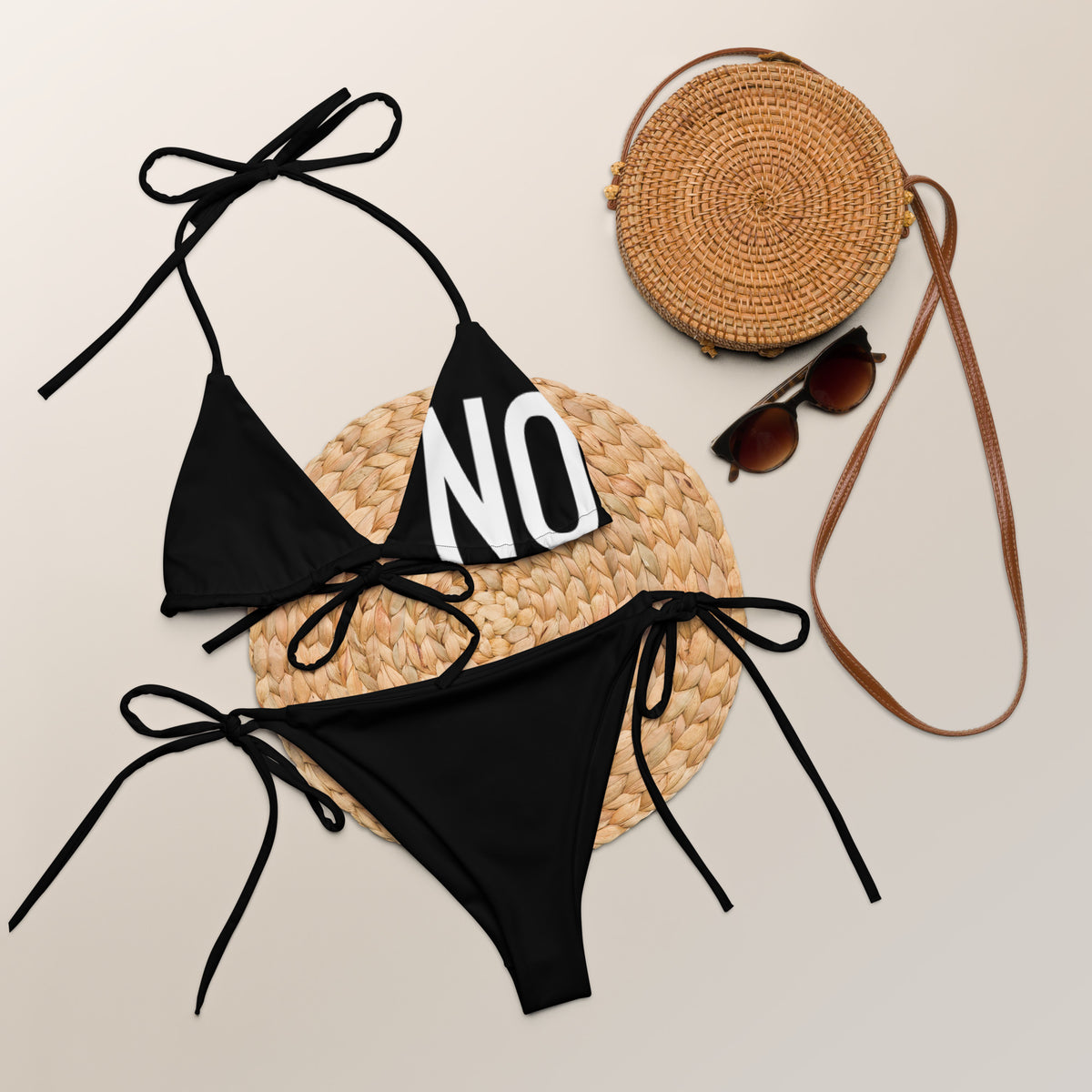 Front facing graphic string bikini swimsuit in color black, featuring the statement 'NO.' in bold white print on the breast cup of the bikini front top. From What Was Said (Statement Apparel + More).