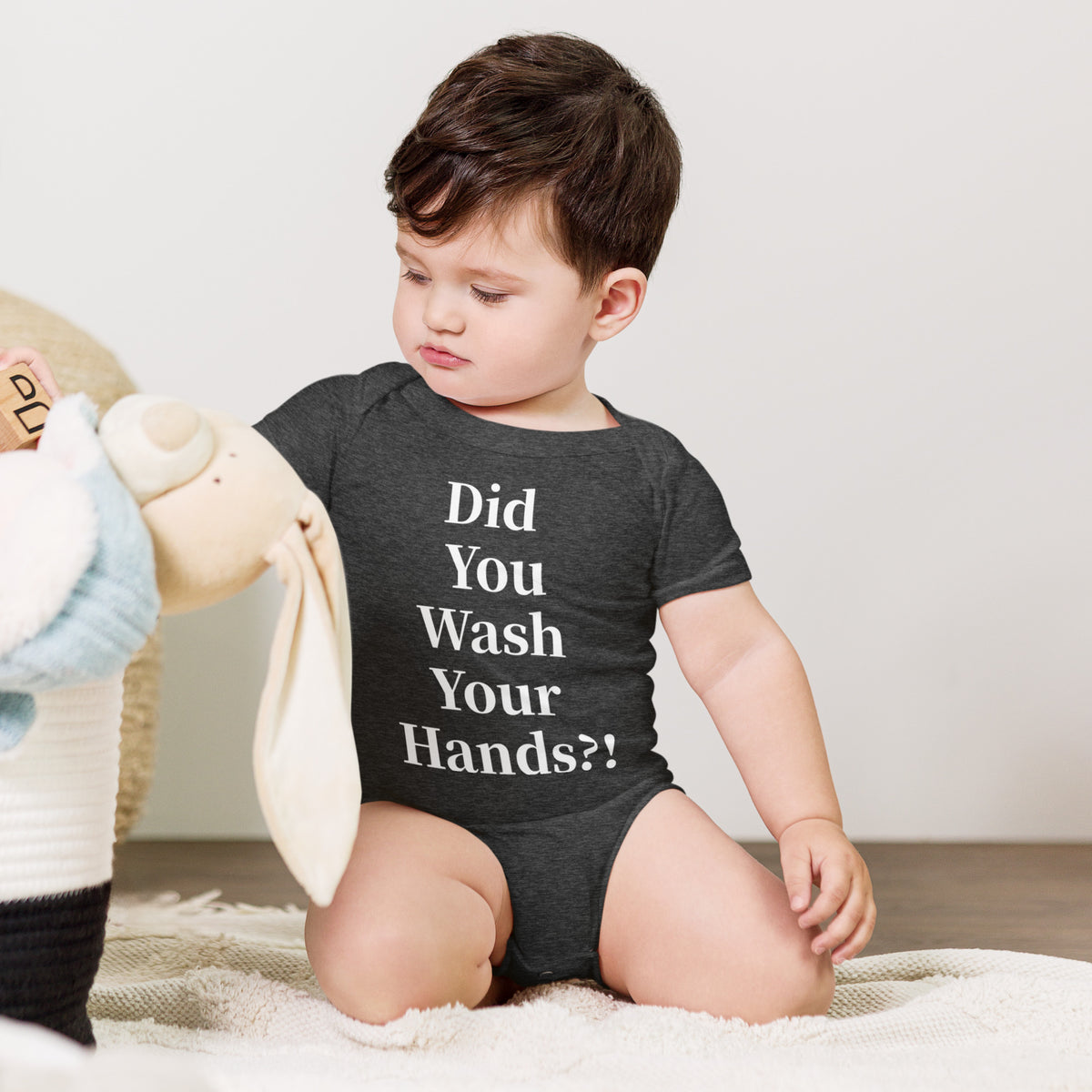 Model wearing front facing graphic onesie in color dark grey heather, featuring statement, 'Did You Wash Your hands,' in white print. From What Was Said (Statement Apparel + More).