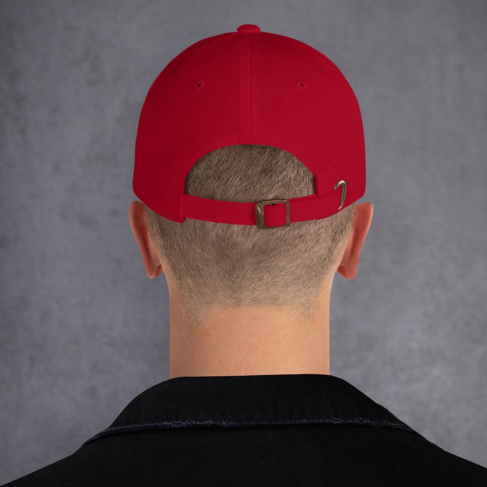 Model is wearing back facing graphic dad hat in color cranberry red, featuring close up view of hats Adjustable strap with antique buckle closure. From What Was Said (Statement Apparel + More).