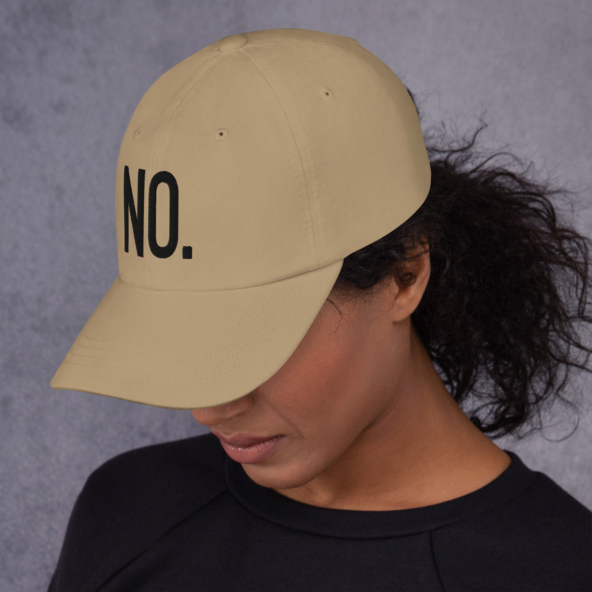 Model is wearing left front facing graphic dad hat in color khaki, featuring the statement 'NO.' in bold black embroidery. From What Was Said (Statement Apparel + More).