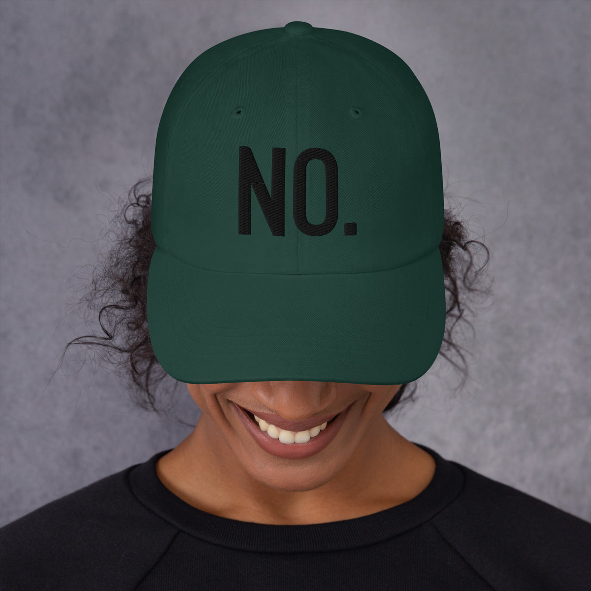 Model is wearing front facing graphic dad hat in color spruce, featuring the statement 'NO.' in bold black embroidery. From What Was Said (Statement Apparel + More).