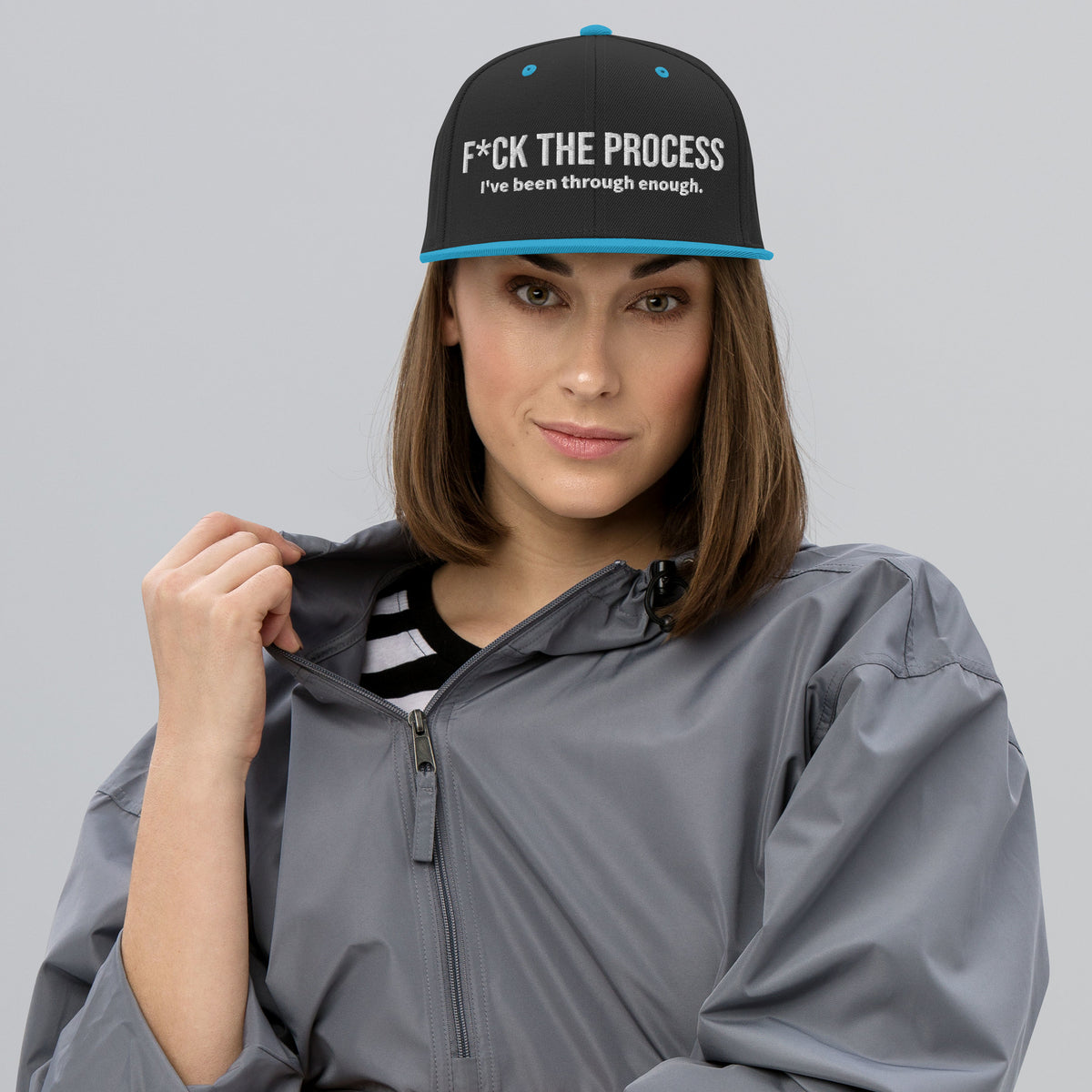 Model is wearing front facing graphic snapback hat in color black and teal, featuring the statement 'FUCK THE PROCESS, I've Been Through Enough,' in bold white embroidery. From What Was Said (Statement Apparel + More).