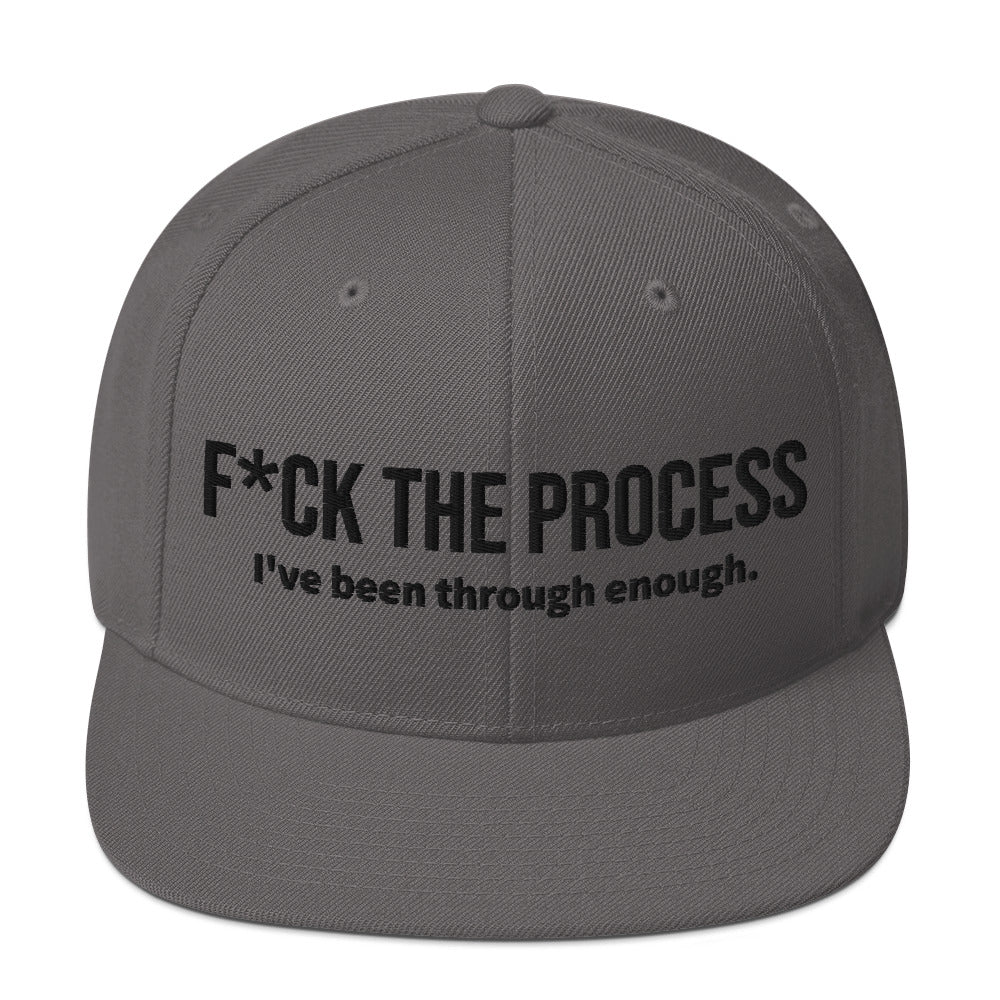 Front facing graphic snapback hat in color dark grey, featuring the statement 'FUCK THE PROCESS, I've Been Through Enough,' in bold black embroidery. From What Was Said (Statement Apparel + More).