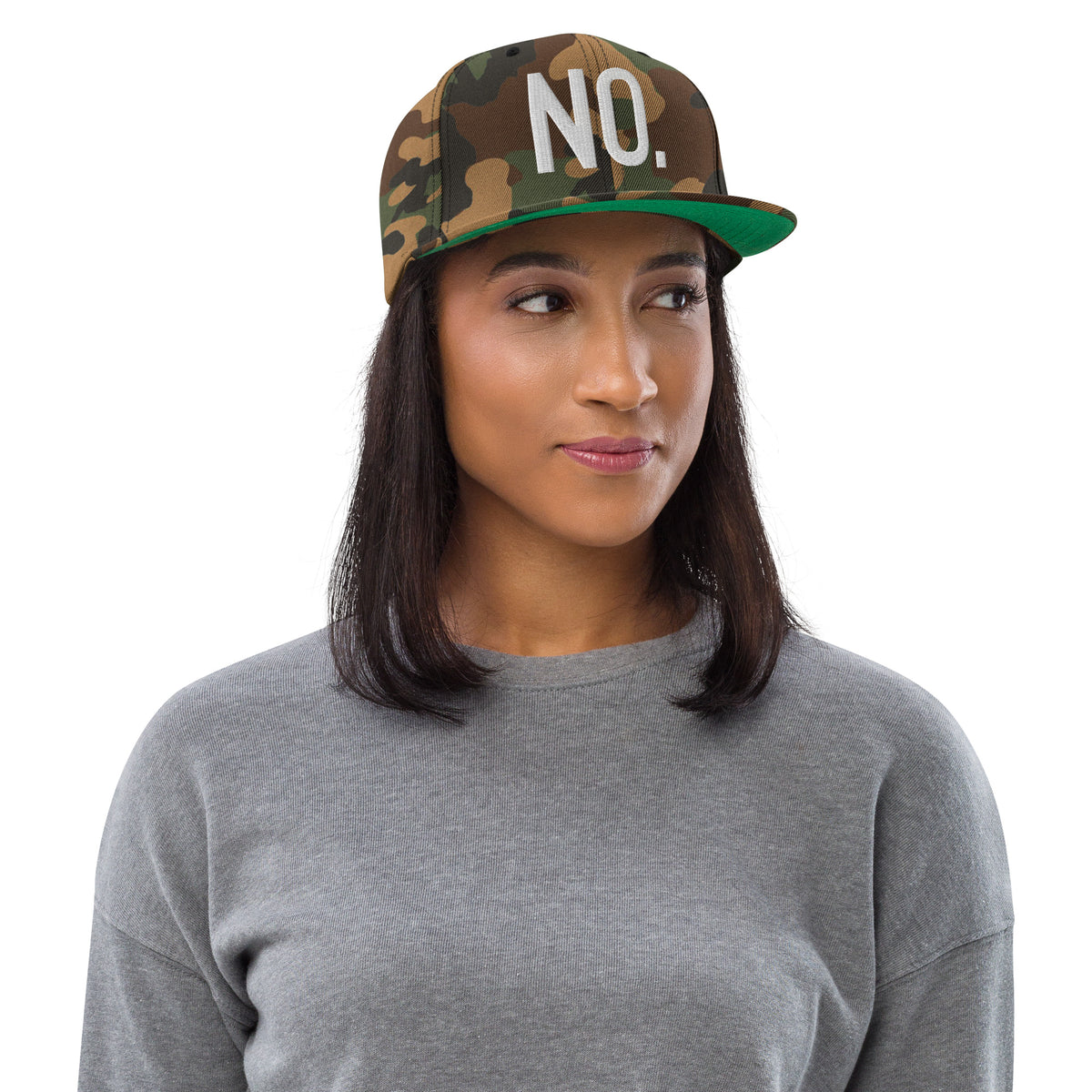 Model wearing front facing graphic snapback hat in color green camo, featuring the statement 'NO.' in bold white embroidery. From What Was Said (Statement Apparel + More).