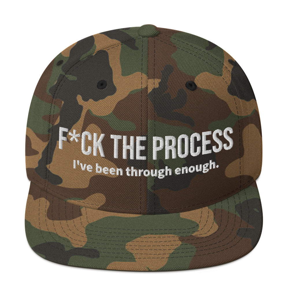 Front facing graphic snapback hat in color green camo, featuring the statement 'FUCK THE PROCESS, I've Been Through Enough,' in bold white embroidery. From What Was Said (Statement Apparel + More).