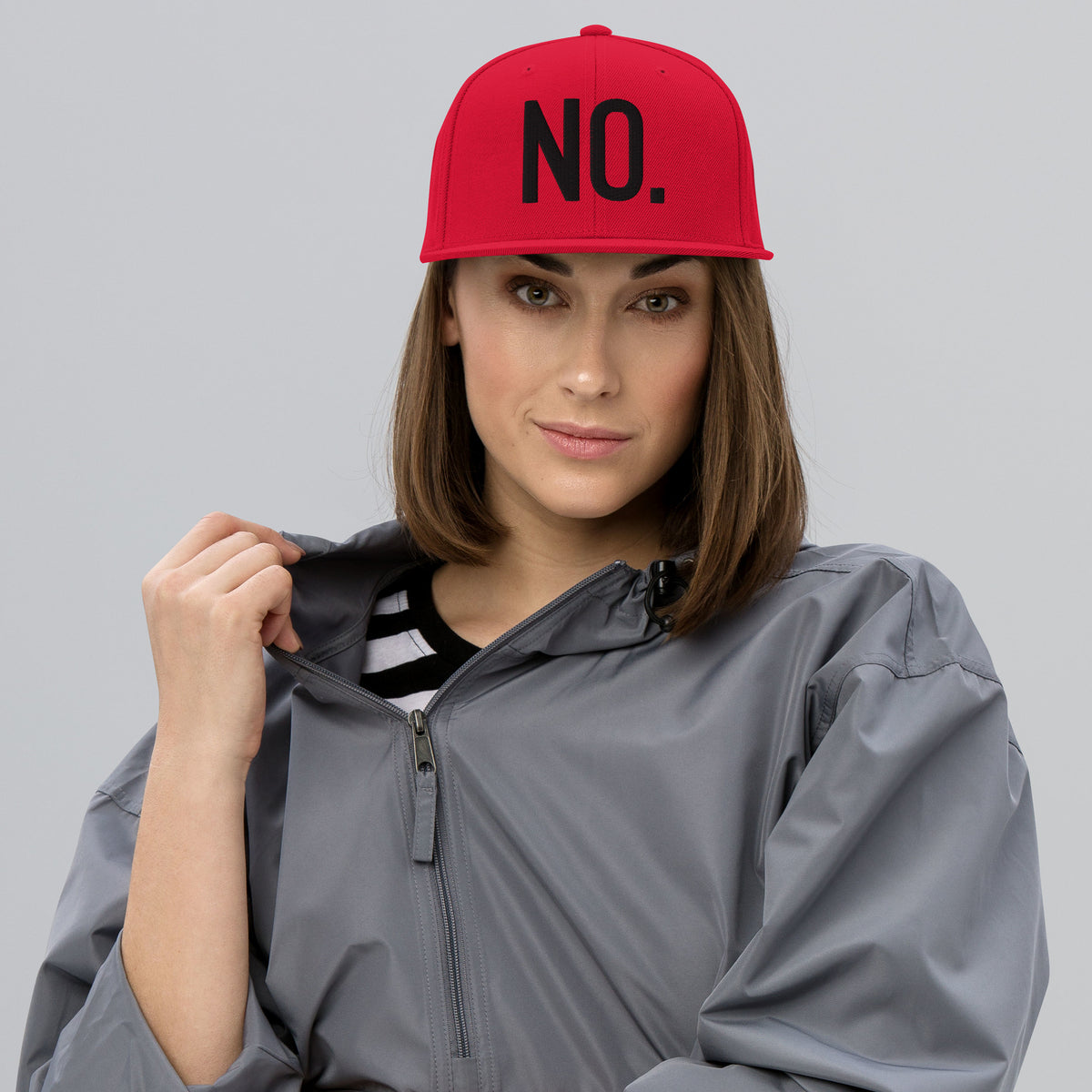 Model wearing front facing graphic snapback hat in color red, featuring the statement 'NO.' in bold black embroidery. From What Was Said (Statement Apparel + More).