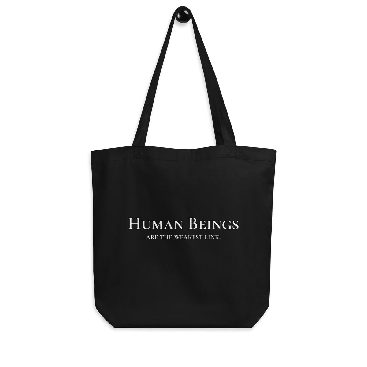 Front-facing graphic eco tote bag in color black, hanging from a hook against white background. Featuring a bold statement, 'Human Beings Are The Weakest link.', in bold white print, from What Was Said (Statement Apparel + More). 