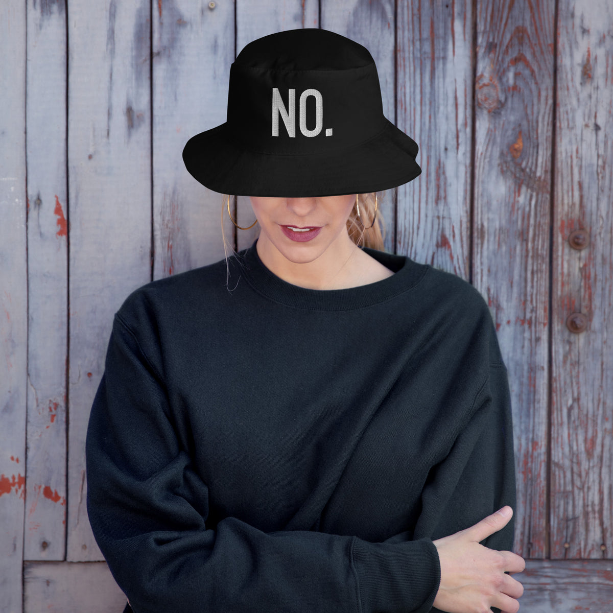Model is wearing front facing graphic bucket hat in color black, featuring the statement 'NO.' in bold white embroidery. From What Was Said (Statement Apparel + More).