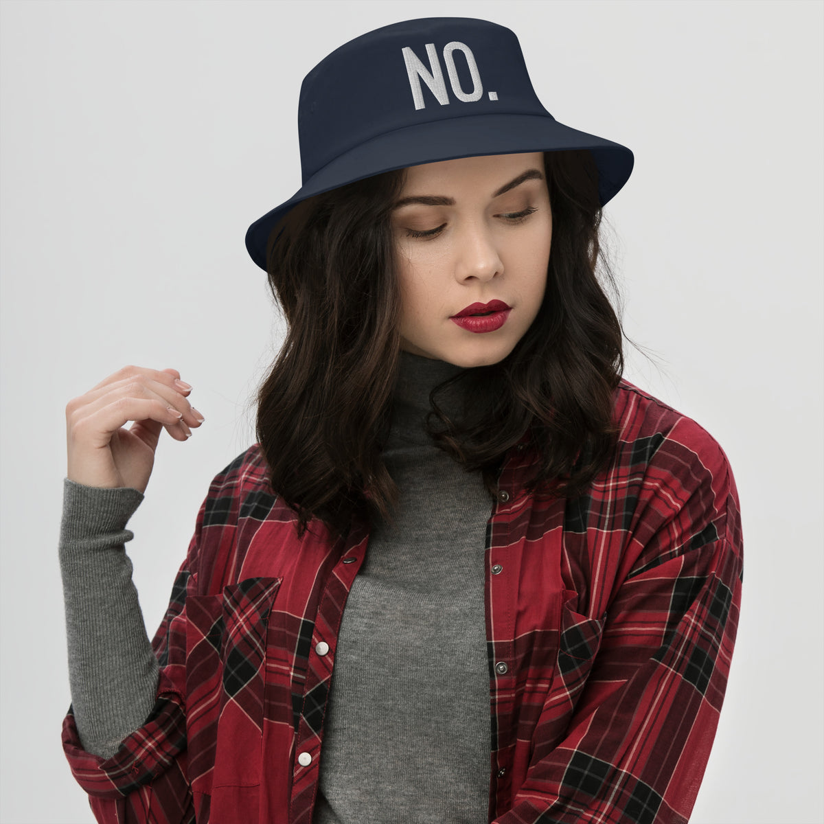 Model is wearing front facing graphic bucket hat in color navy blue, featuring the statement 'NO.' in bold white embroidery. From What Was Said (Statement Apparel + More).