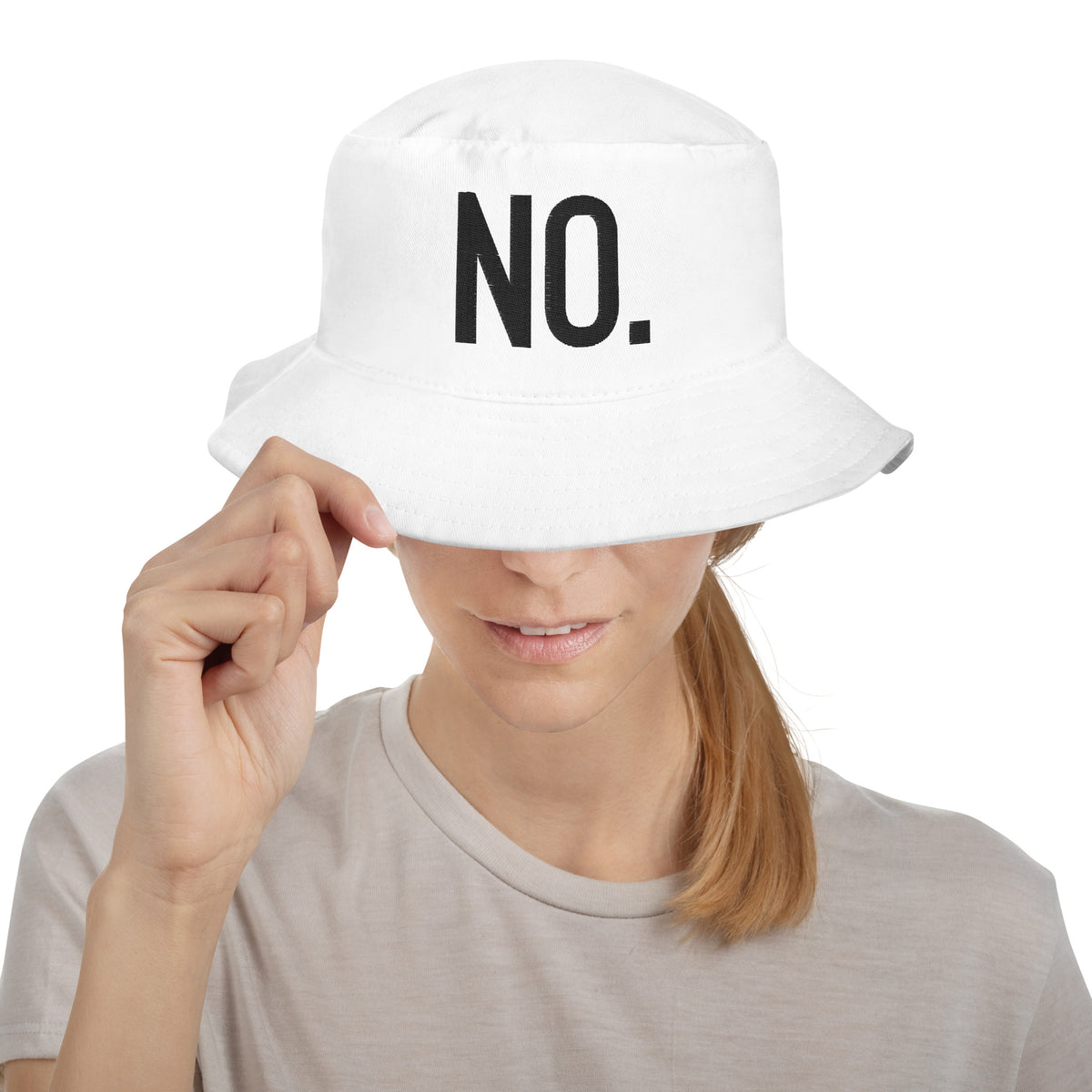 Model wearing front facing graphic bucket hat in color white, featuring the statement 'NO.' in bold black embroidery. From What Was Said (Statement Apparel + More).