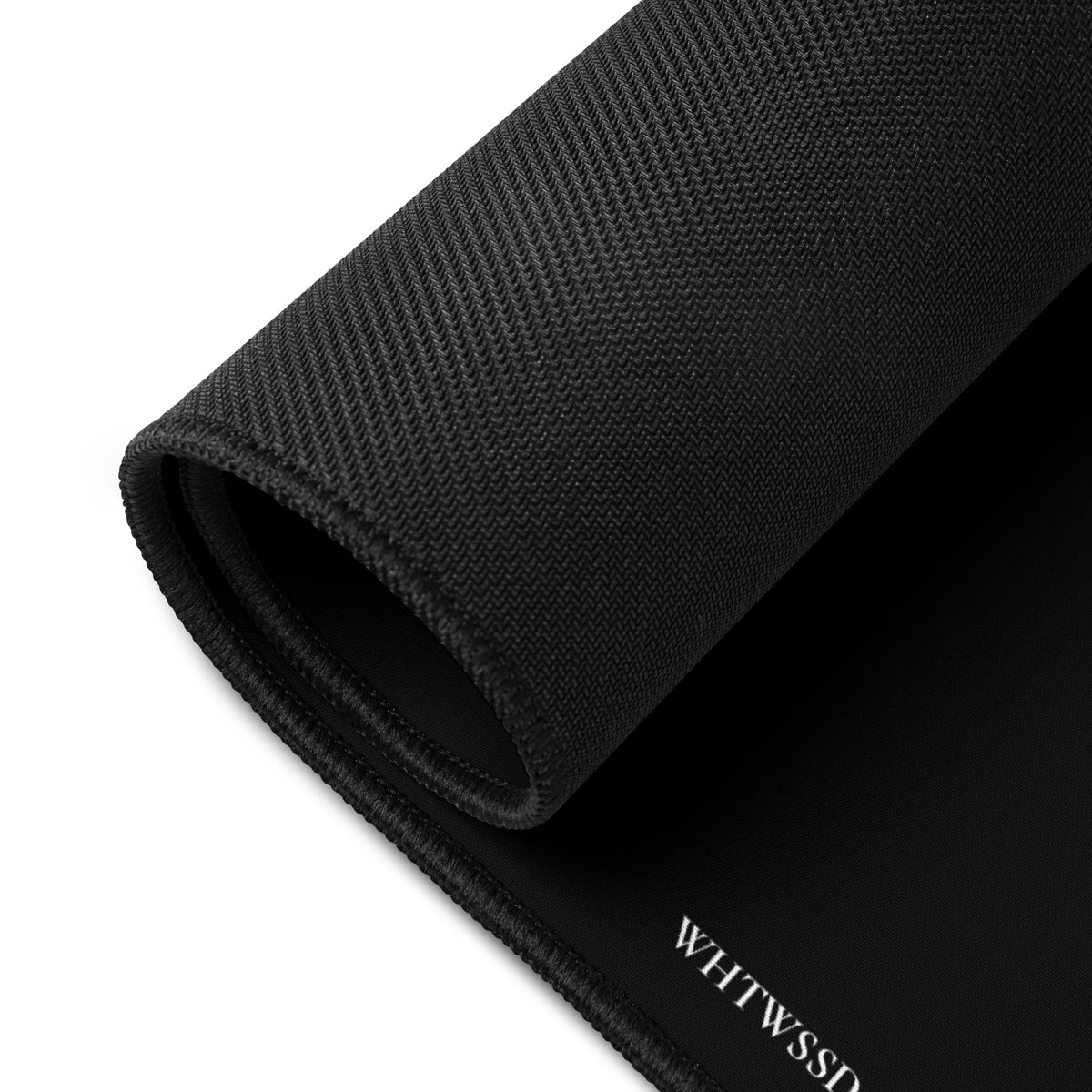 Product detail of 12x18 graphic desk mat in color black, against white background. Featuring anti-slip natural rubber base backing and brand logo website, WHTWSSD.COM, in small print in the bottom left corner. From What Was Said (Statement Apparel + More). 