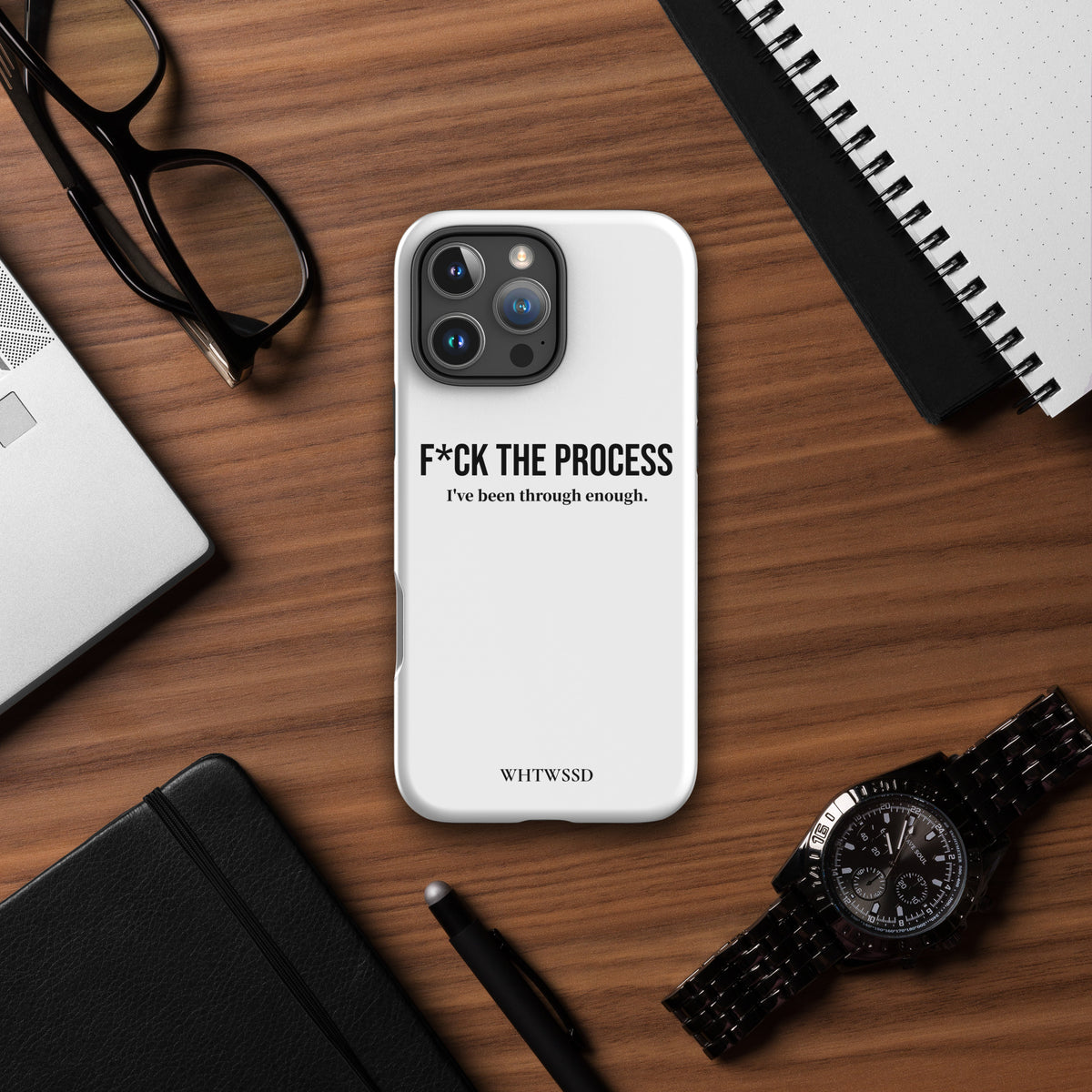 Front facing graphic iPhone 16 Pro Max case, against desk background. Featuring the statement 'F*CK THE PROCESS, I've been through enough.' in bold black print on the phone case. From What Was Said (Statement Apparel + More). 