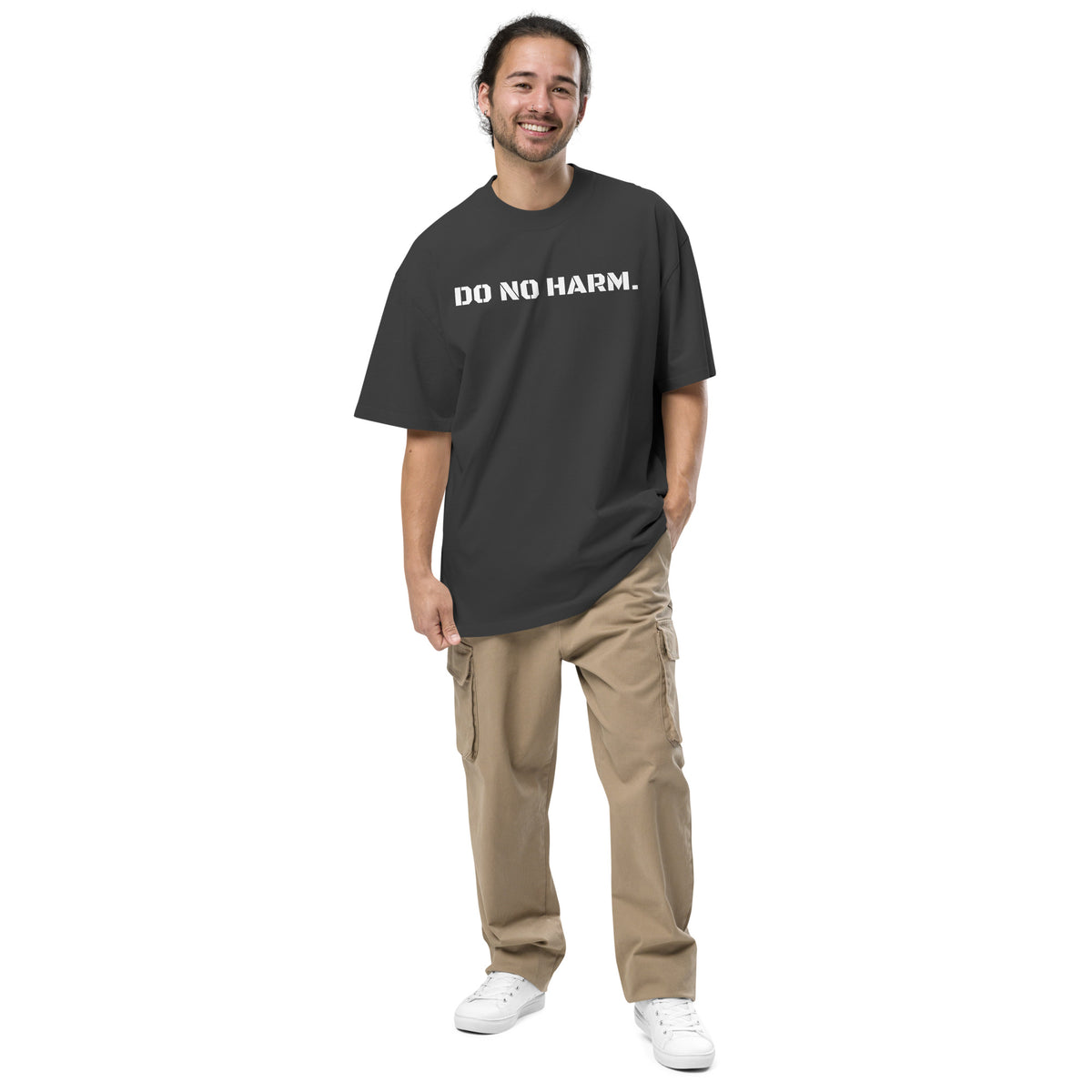 Model wearing front facing oversized fit graphic t-shirt in color faded black, featuring statement that reads 'DO NO HARM', in bold white print. From What Was Said (Statement Apparel + More).