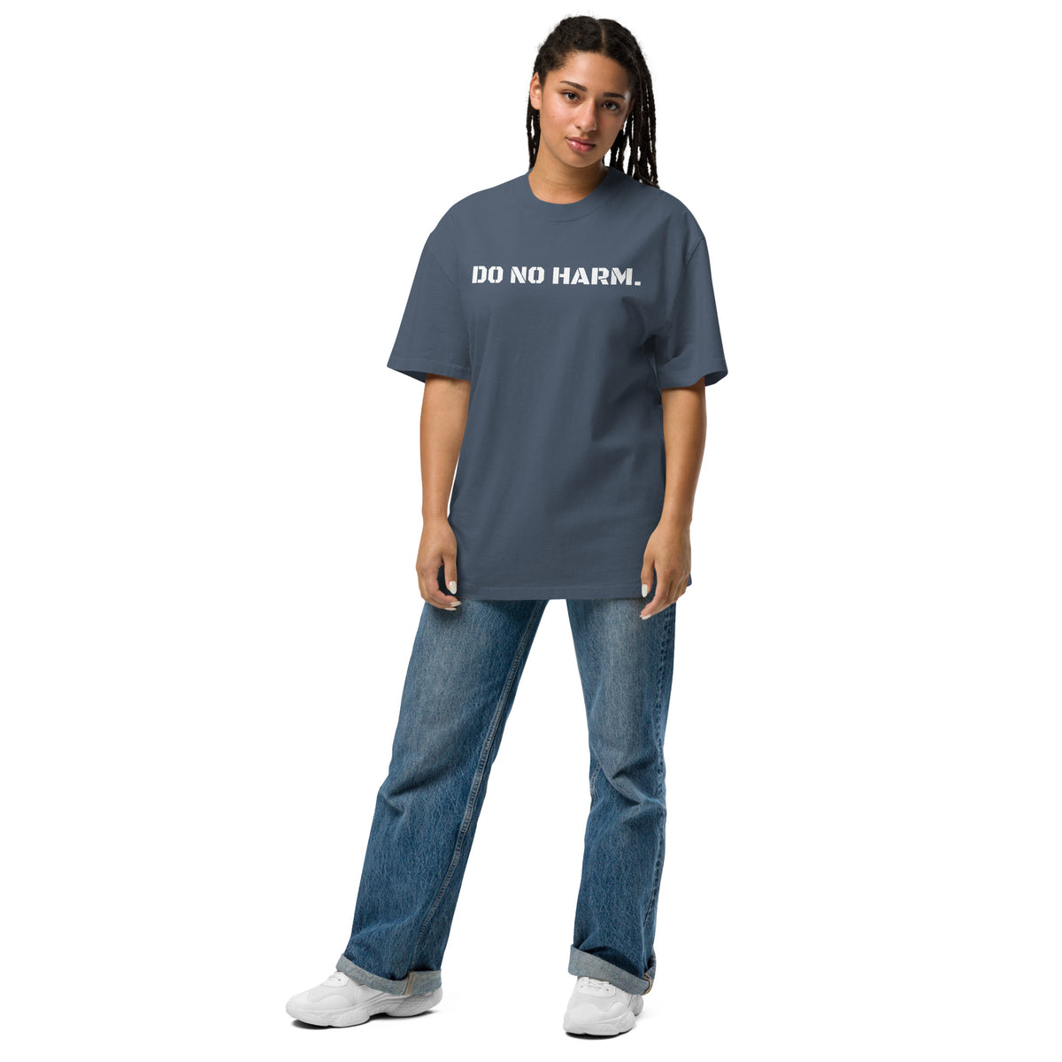 Model wearing front facing oversized fit graphic t-shirt in color faded indigo, featuring statement that reads 'DO NO HARM', in bold white print. From What Was Said (Statement Apparel + More).