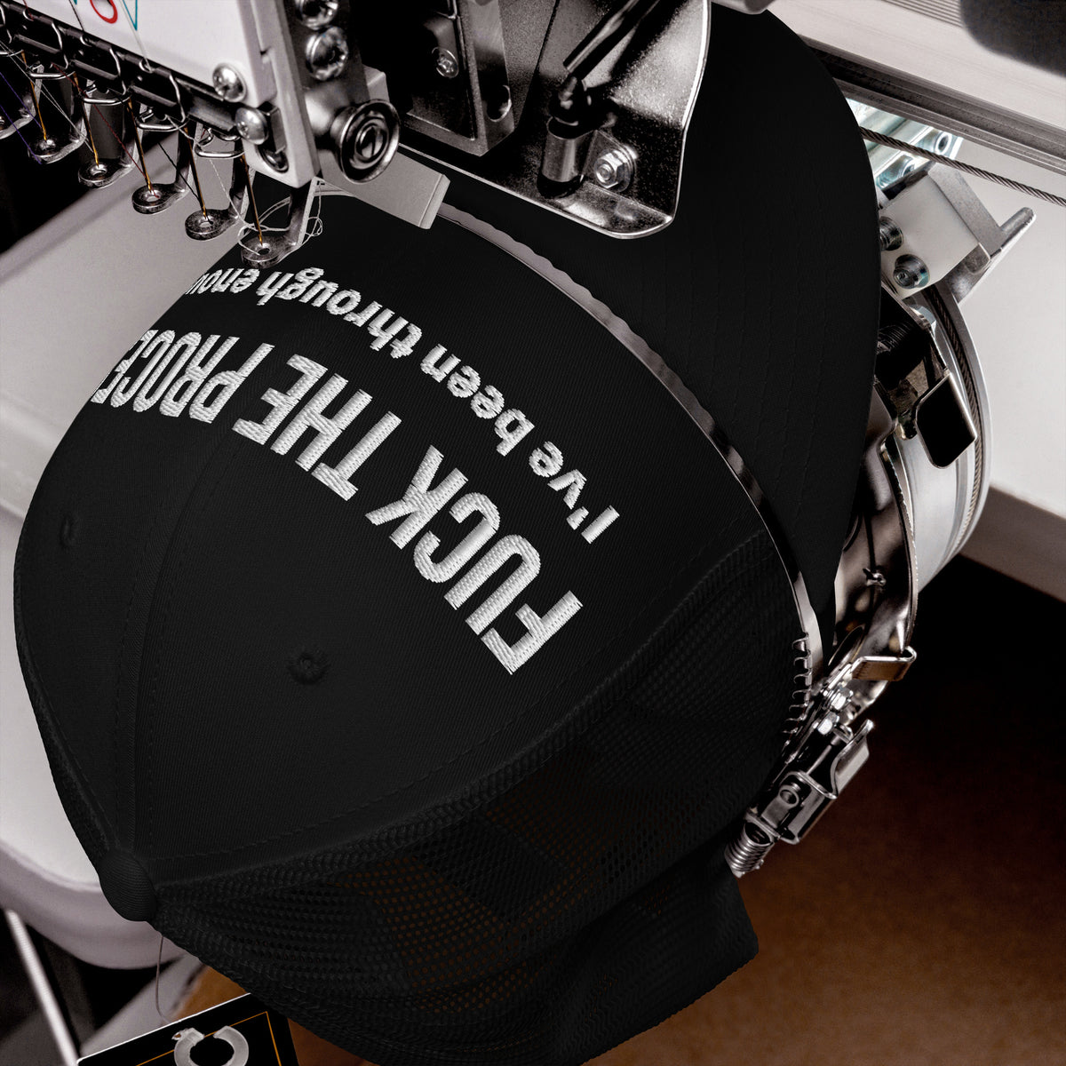 Product detail of embroidered stitching on front facing graphic trucker hat in color black, featuring the statement 'FUCK THE PROCESS, I've Been Through Enough,' in bold white embroidery. From What Was Said (Statement Apparel + More).