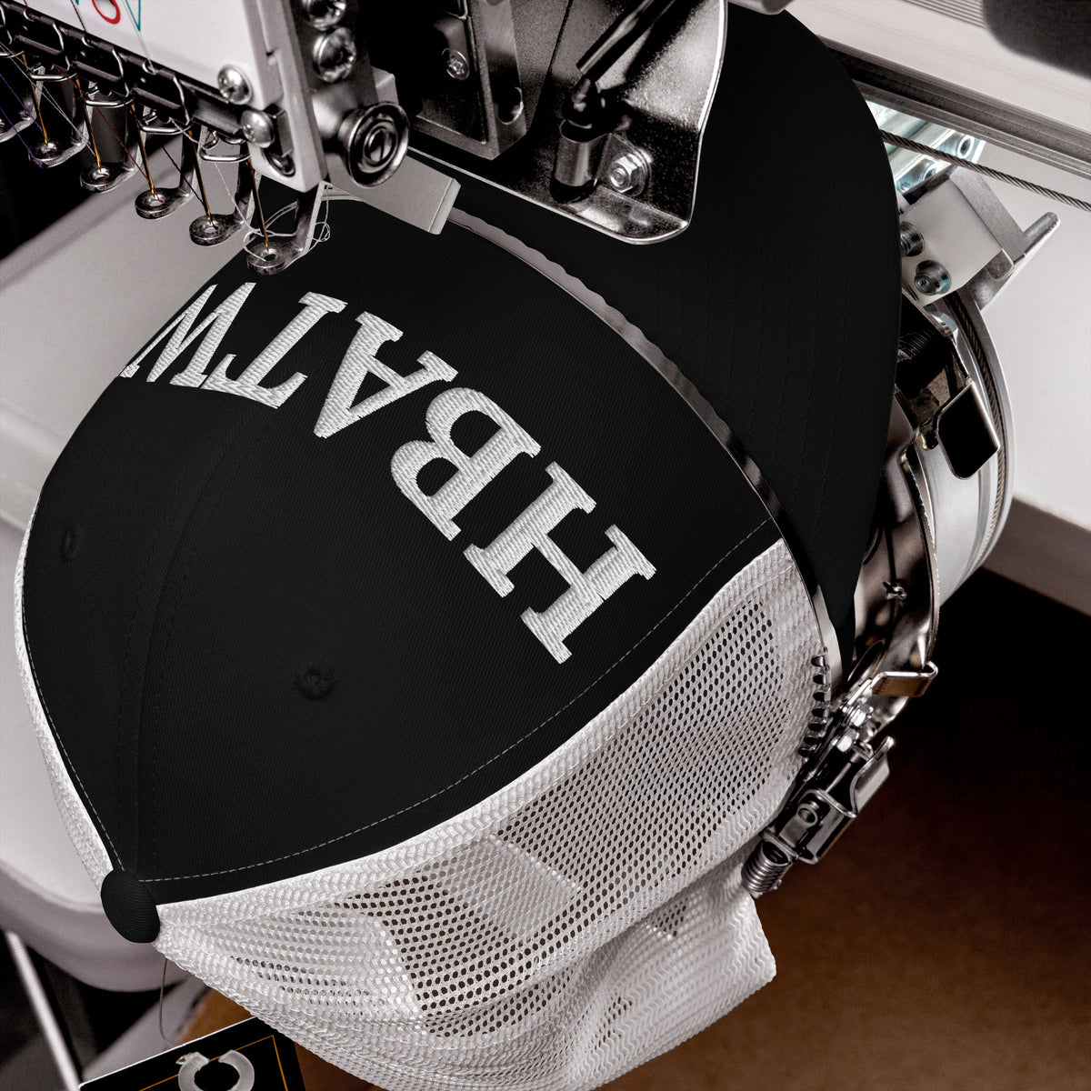Product detail of embroidered stitching on front facing graphic trucker hat in color black and white, featuring the initialism 'HBATWL', from What Was Said (Statement Apparel + More).