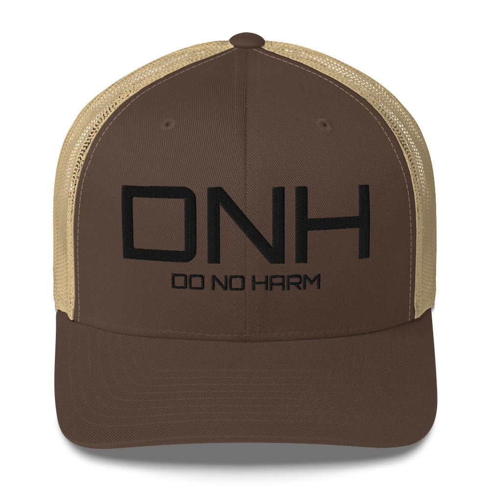 Front facing graphic trucker hat in color brown and khaki, featuring the initialism 'DNH', and the statement 'DO NO HARM,' in bold black embroidery. From What Was Said (Statement Apparel + More).