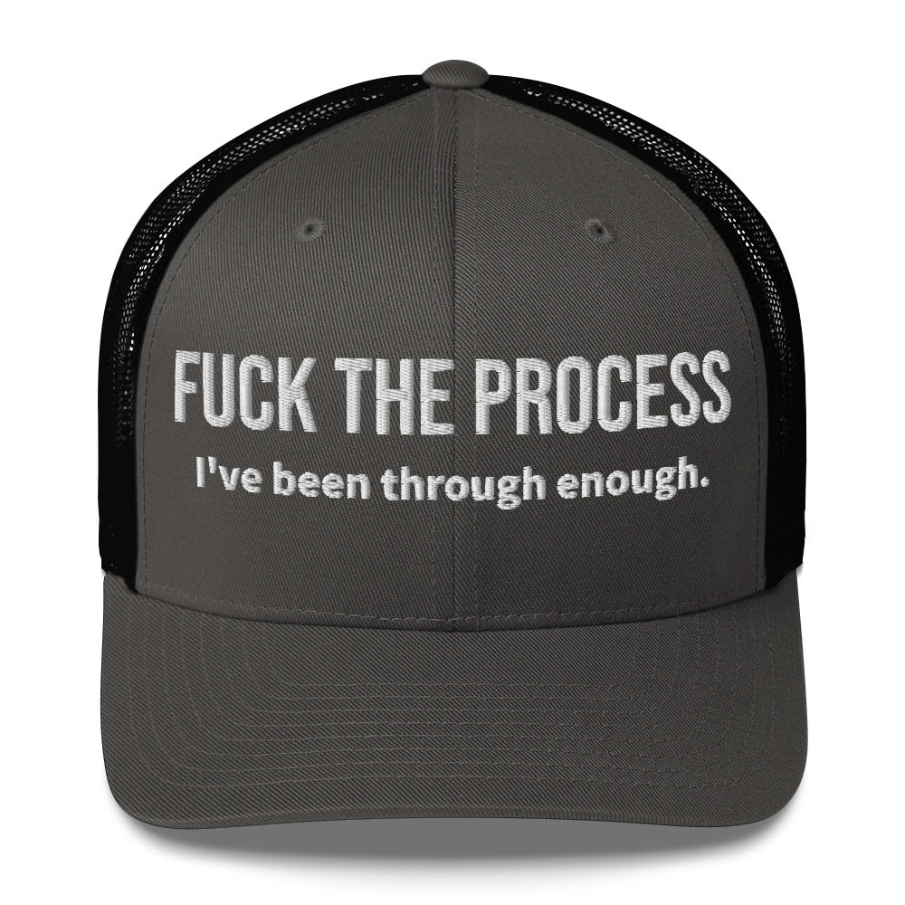 Front facing graphic trucker hat in color charcoal and black, featuring the statement 'FUCK THE PROCESS, I've Been Through Enough,' in bold white embroidery. From What Was Said (Statement Apparel + More).