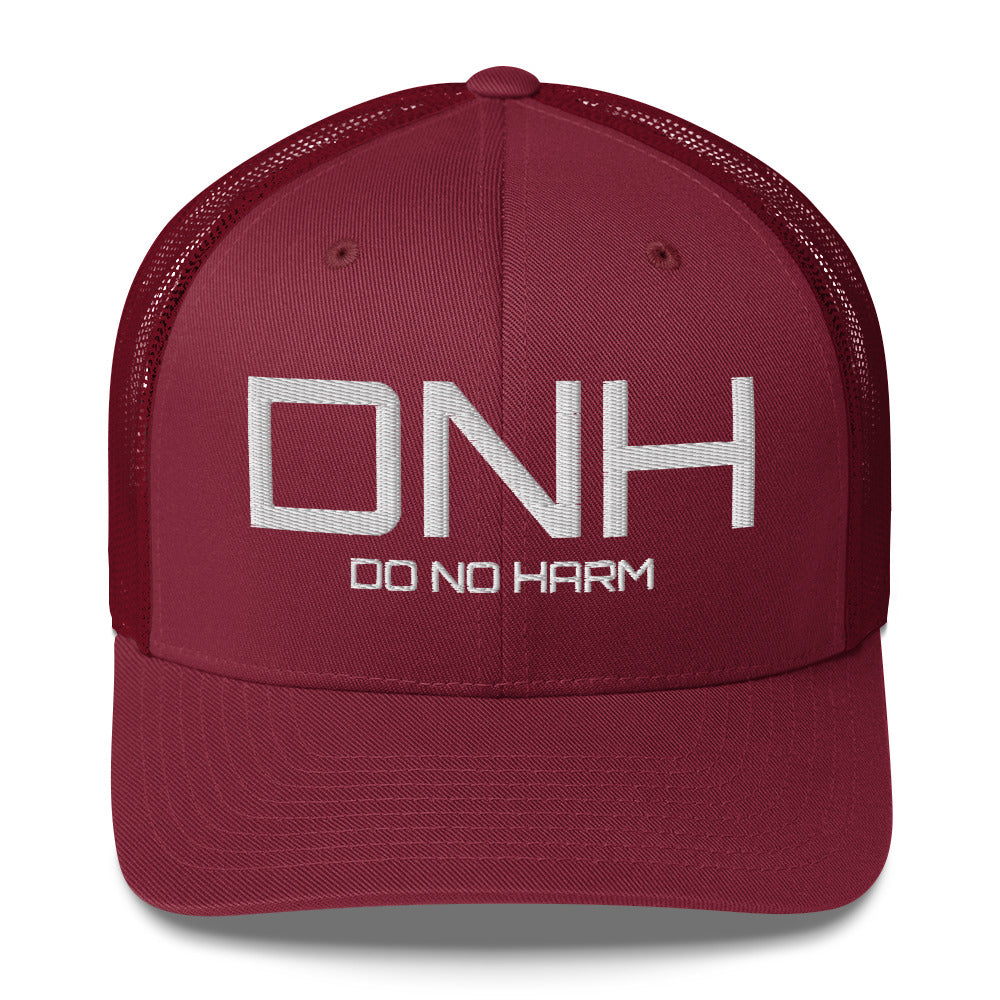 Front facing graphic trucker hat in color maroon red, featuring the initialism 'DNH', and the statement 'DO NO HARM,' in bold white embroidery. From What Was Said (Statement Apparel + More).