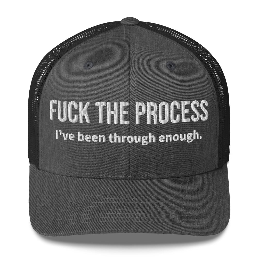 Front facing graphic trucker hat in color dark heather grey, featuring the statement 'FUCK THE PROCESS, I've Been Through Enough,' in bold white embroidery. From What Was Said (Statement Apparel + More).