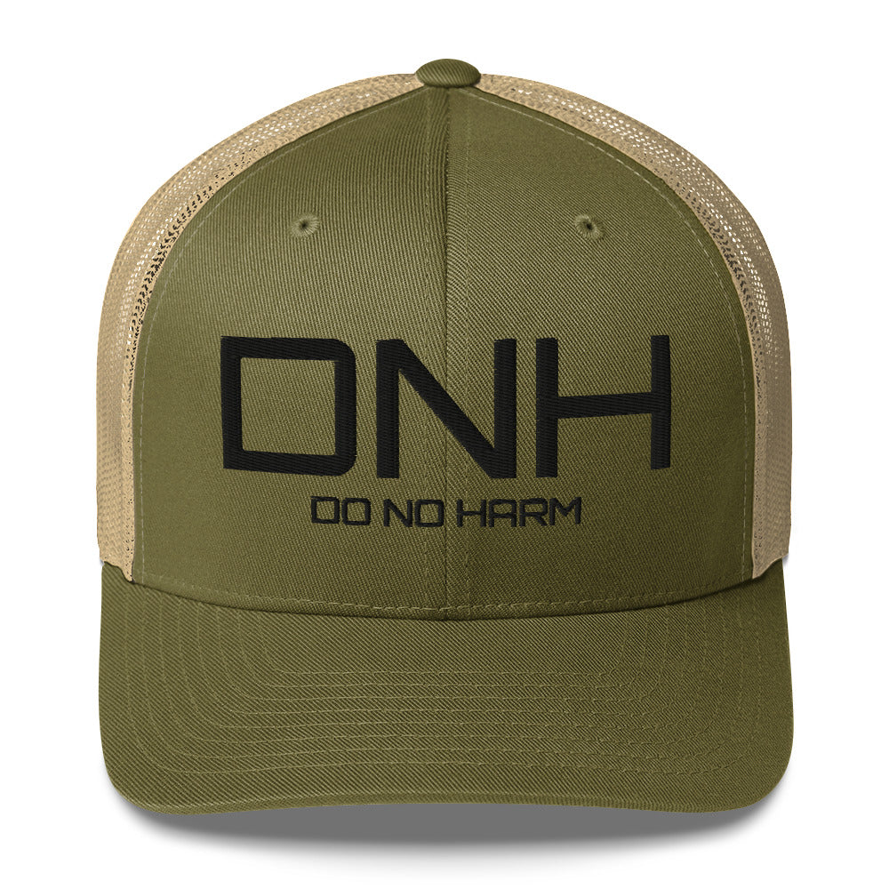 Front facing graphic trucker hat in color moss green and khaki, featuring the initialism 'DNH', and the statement 'DO NO HARM,' in bold black embroidery. From What Was Said (Statement Apparel + More).