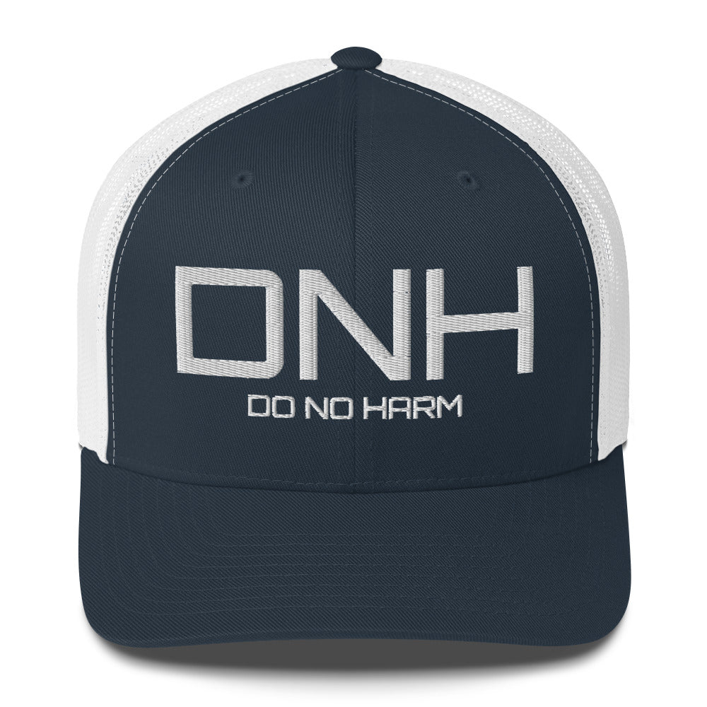 Front facing graphic trucker hat in navy blue and white, featuring the initialism 'DNH', and the statement 'DO NO HARM,' in bold white embroidery. From What Was Said (Statement Apparel + More).