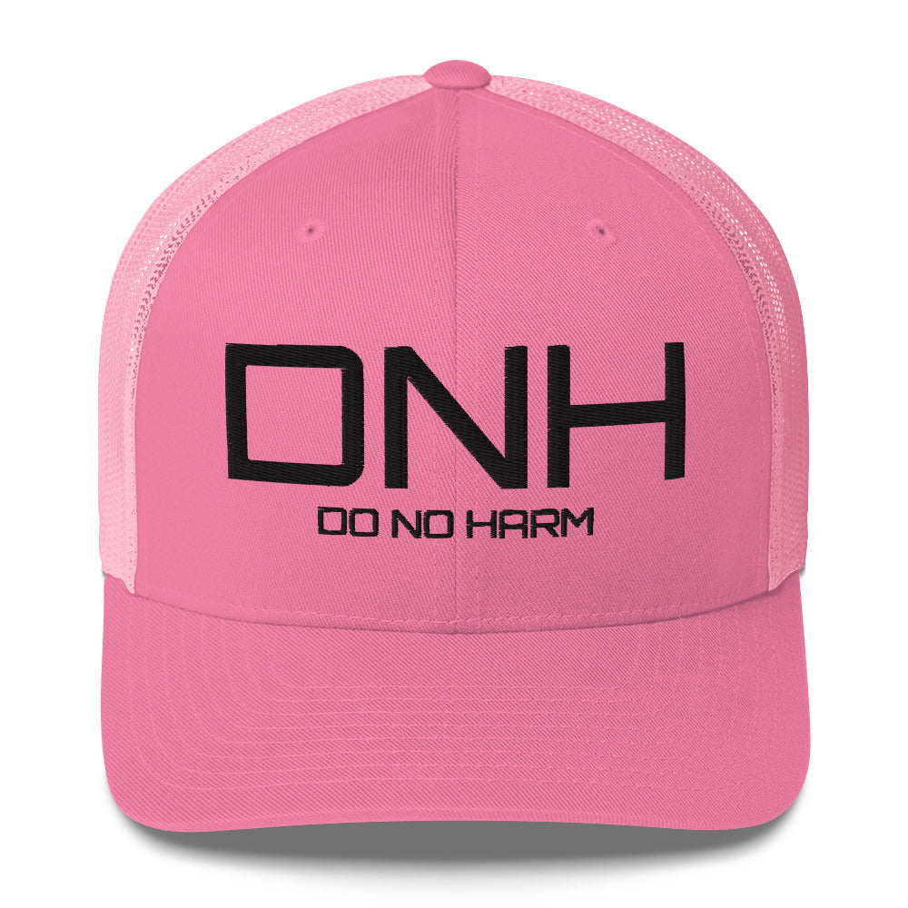 Front facing graphic trucker hat in color pink, featuring the initialism 'DNH', and the statement 'DO NO HARM,' in bold black embroidery. From What Was Said (Statement Apparel + More).