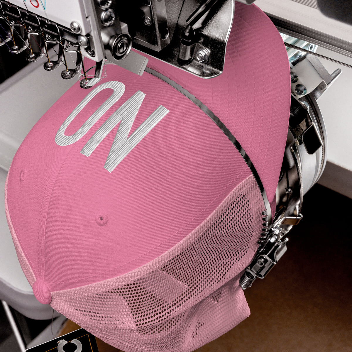 Product detail of embroidered stitching on front facing graphic trucker hat in color pink, featuring the statement 'NO' in bold white embroidery. From What Was Said (Statement Apparel + More).