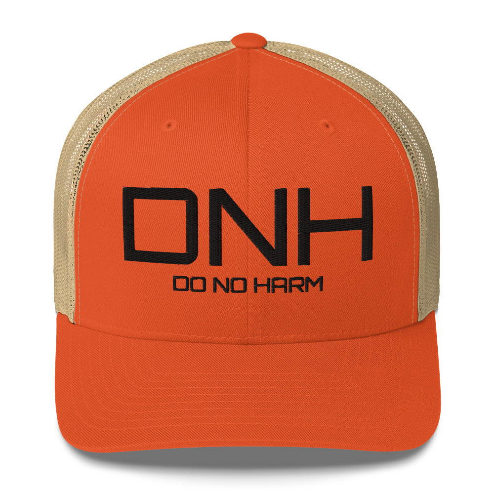 Front facing graphic trucker hat in color rustic orange, featuring the initialism 'DNH', and the statement 'DO NO HARM,' in bold black embroidery. From What Was Said (Statement Apparel + More).