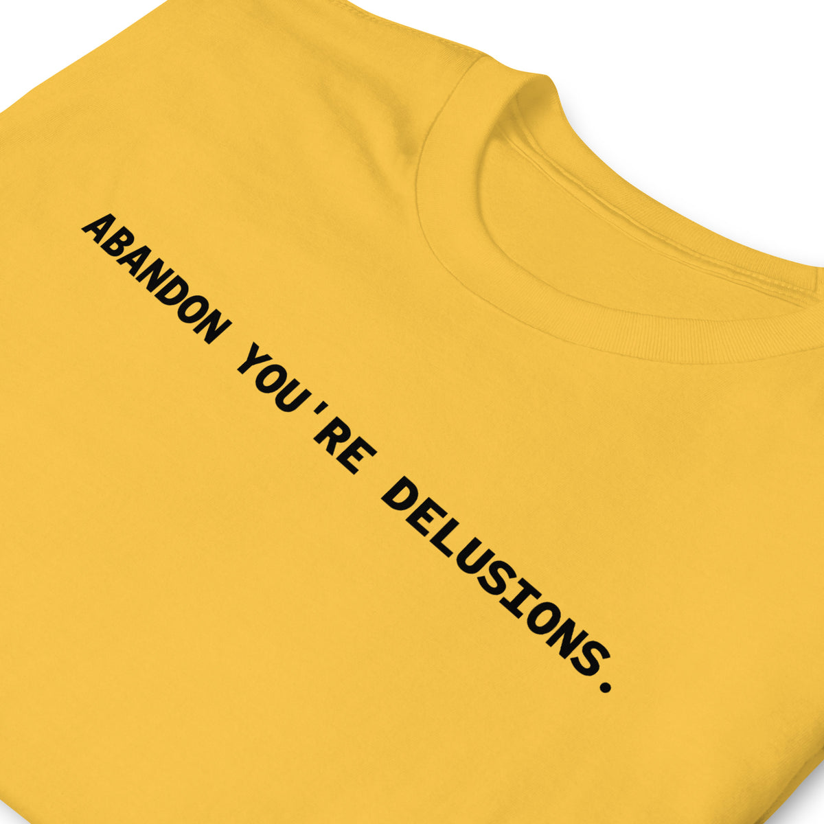 Zoomed in front facing folded graphic t-shirt in color daisy yellow, featuring statement, 'ABANDON YOU'RE DELUSIONS', in bold black print. From What Was Said (Statement Apparel + More).