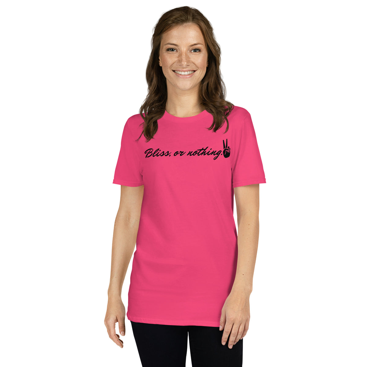 Model is wearing front facing graphic t-shirt in color heliconia pink, featuring statement, 'Bliss, or nothing,' with a hand showing the peace sign, in bold black cursive print. With a hand showing the peace sign at the end of the statement. From What Was Said (Statement Apparel + More).