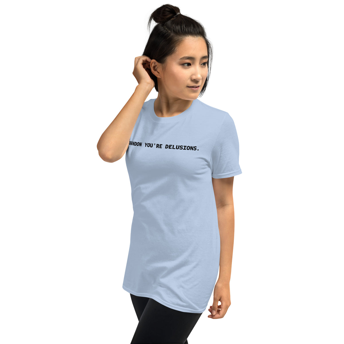 Model is wearing left front facing graphic t-shirt in color light blue, featuring statement, 'ABANDON YOU'RE DELUSIONS', in bold black print. From What Was Said (Statement Apparel + More).