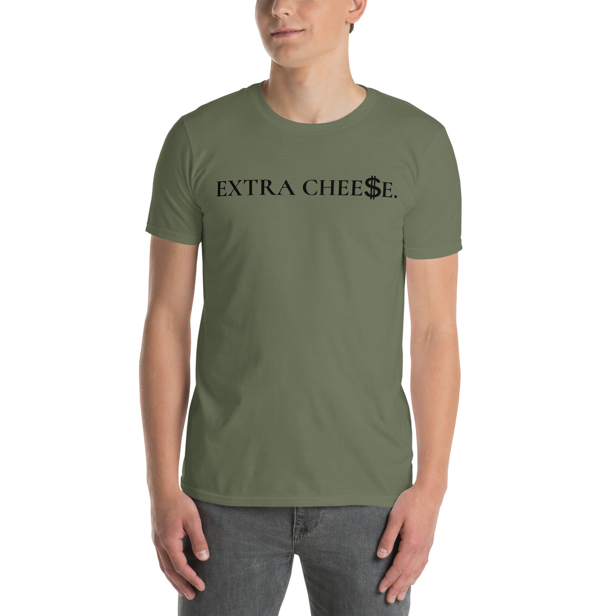 Model is wearing front facing graphic T-shirt in color military green, featuring statement 'EXTRA CHEESE', with dollar sign symbol in place of the letter S in the word cheese, in black print. From What Was Said (Statement Apparel + More).