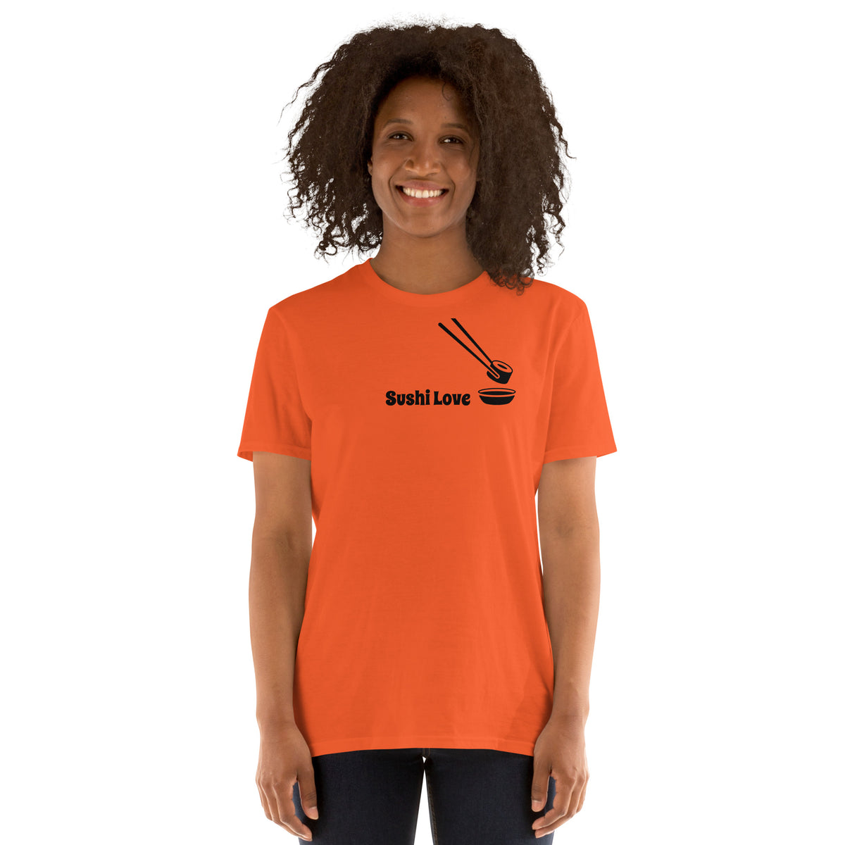 Model wearing front facing graphic T-shirt in color orange, featuring printed image of sushi, and the written words, 'SUSHI LOVE' in black print. From What Was Said (Statement Apparel + More).