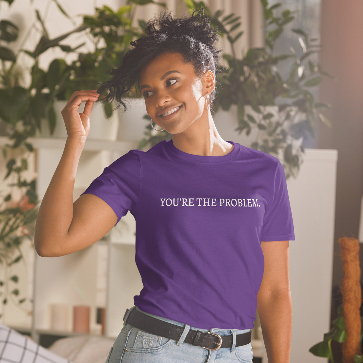 Model is wearing front facing graphic t-shirt in color purple featuring statement, 'YOU'RE THE PROBLEM', in bold white print. From What Was Said (Statement Apparel + More).