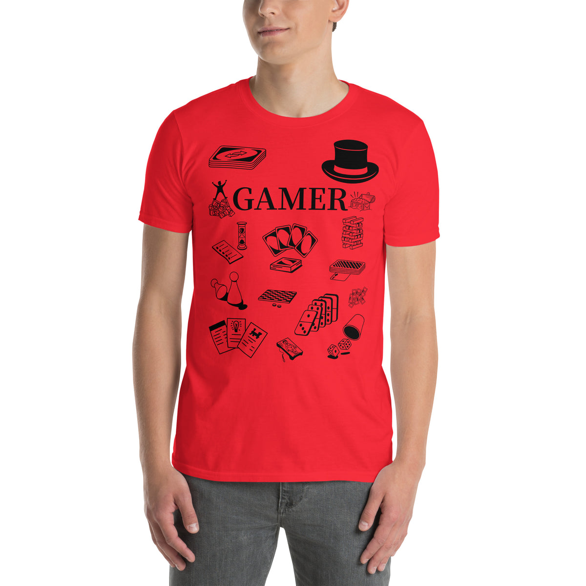Model is standing against a white background wearing front facing graphic T-shirt in color red, featuring printed image of various classic board game pieces and the word 'GAMER' in black print, from What Was Said (Statement Apparel + More). 
