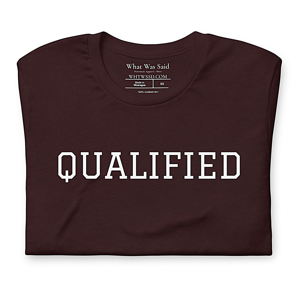 Folded front facing graphic T-shirt in color oxblood dark reddish black featuring the word 'QUALIFIED' in bold white print, from What Was Said (Statement Apparel + More).