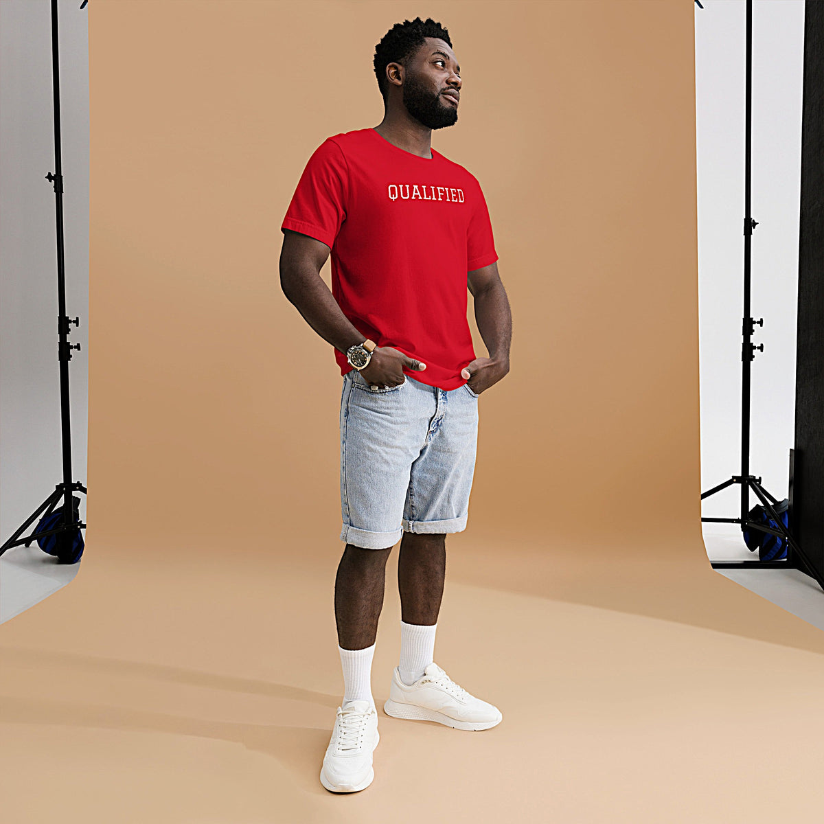 Model wearing front-facing graphic T-shirt in color red featuring the word 'QUALIFIED' in bold white print, from What Was Said (Statement Apparel + More).